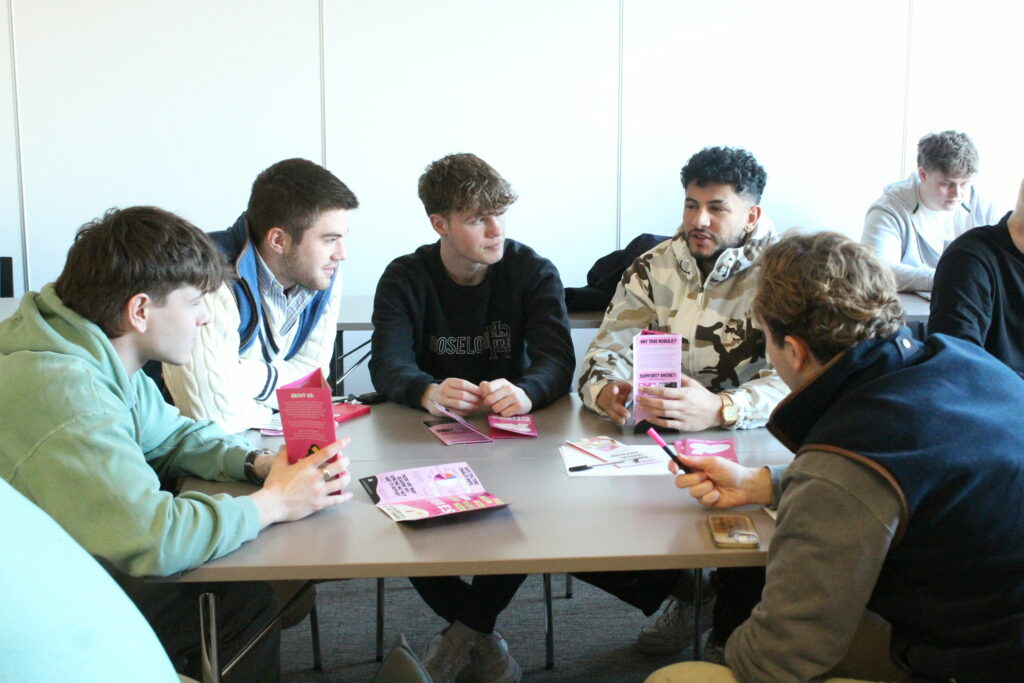 A group of men sat around a table having a discussion at an AAA semianr